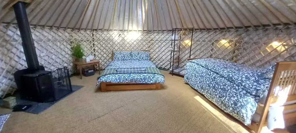 Family glamping yurt twin beds - Visit our Oxford Show yurt or Speak to Us A comfortable double bed in a yurt decorated with warm fairy lights and plush blue bedding.