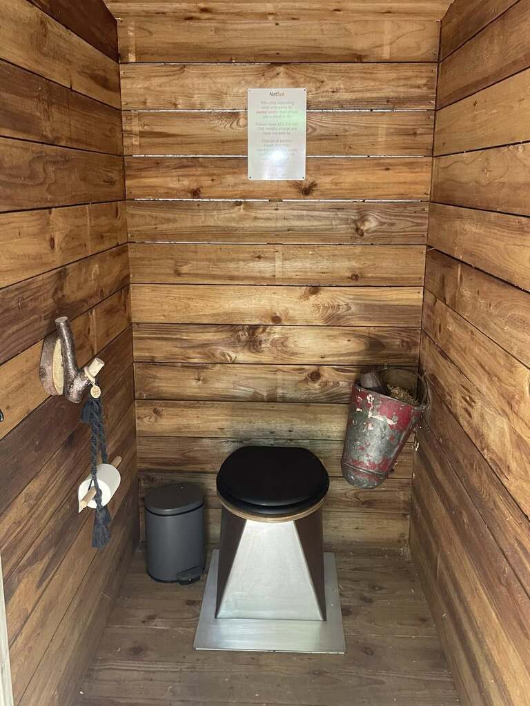 A compost toilet inside a small wood-panelled room