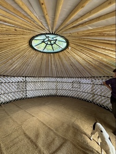 Inside The Yurt: A Space for Learning and Play - Welcome to Yurt Specialists A interval of a traditional Mongolian yurt, featuring wooden lactic wall, radiant ceiling poles, and a beautiful skylight. The floor is covered in natural matting ready for children to learn and play.
